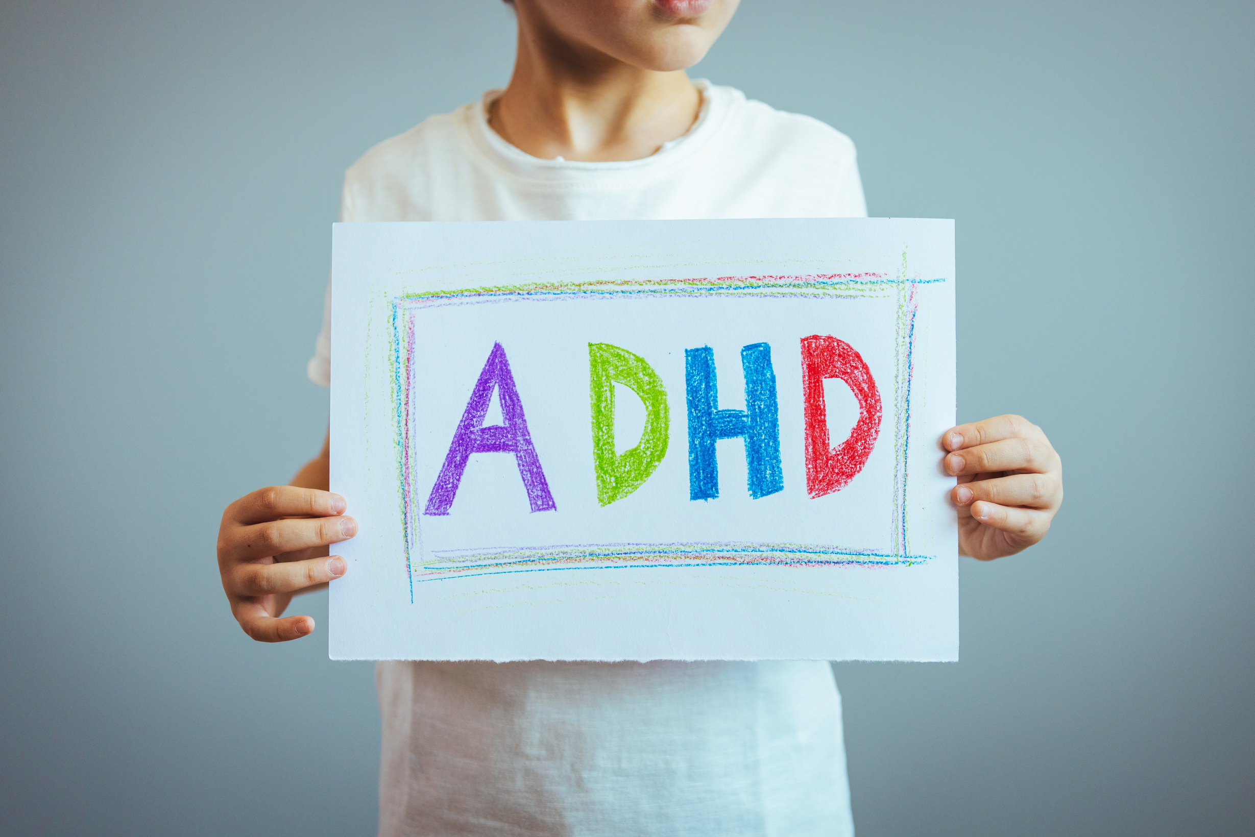 a child holding a sign with the word adhd